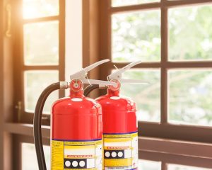 Fire extinguishers placed near a window, ready for emergency use - fire extinguisher for electrical